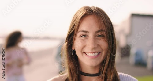 Young brown haired woman laughing with friends in the background