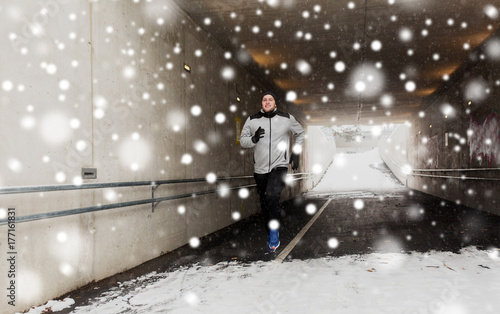 happy man running along subway tunnel in winter