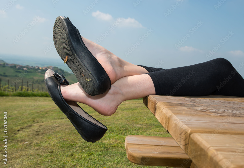 Girl dangling flat shoes on a wood table 素材庫相片| Adobe Stock