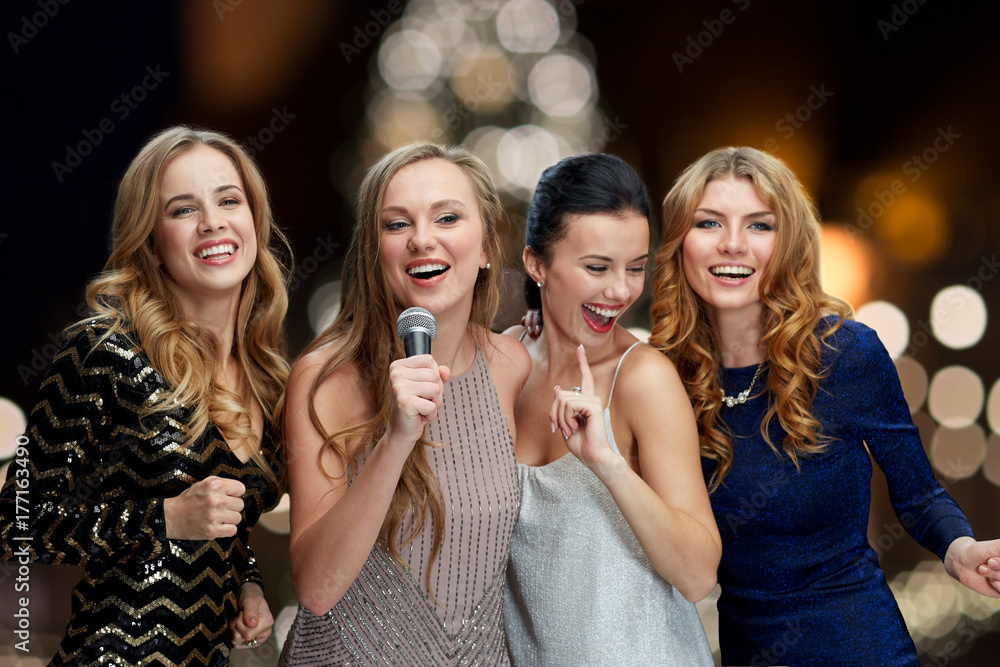 women with microphone singing karaoke at christmas