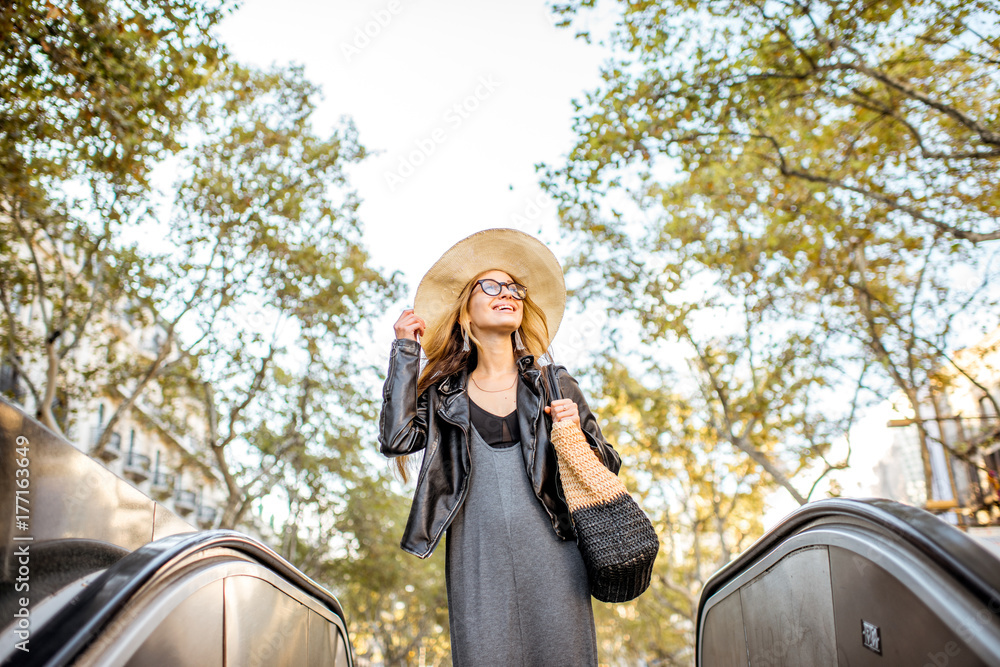 Obraz premium Young woman tourist in hat walking on the famous pedestrian boulevard in Barcelona city