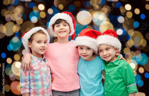 happy little children in santa hats hugging