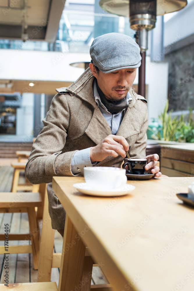 Good-Looking Young Asian Man Having Espresso in Bright Cafe Good-Looking Young Asian Man Having Espresso in Bright Cafe