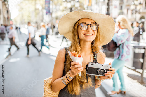 Photography Young woman tourist holding jamon walking outdoors on the street in Barcelona ci