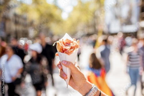 Photography Holding jamon traditional spanish jerked meat outdoors on the street in Barcelon