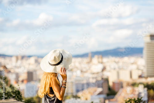 Canvas Print Young woman tourist in hat enjoying great cityscape view on Barcelona