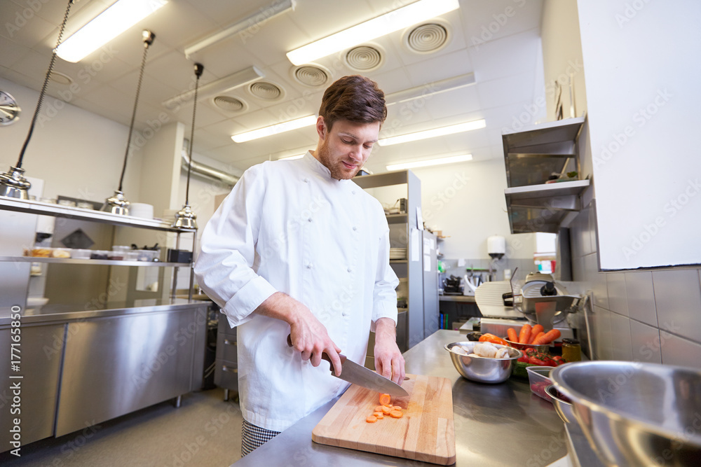 happy male chef cooking food at restaurant kitchen happy male chef cooking food at restaurant kitchen