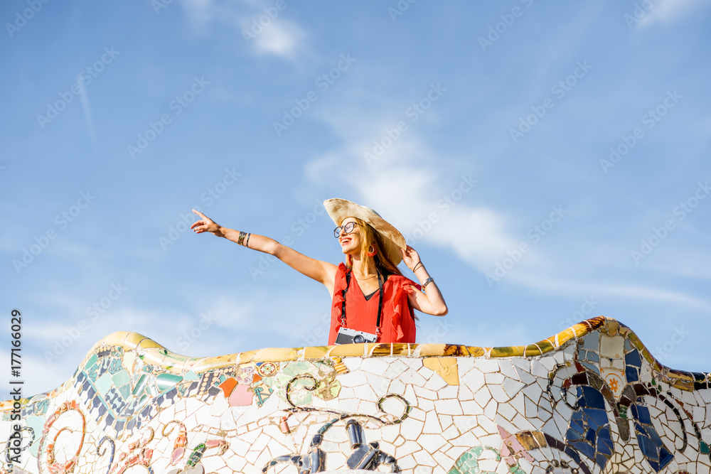 Obraz premium View on the beautiful terrace decorated with mosaic with happy woman tourist in Guell park in Barcelona