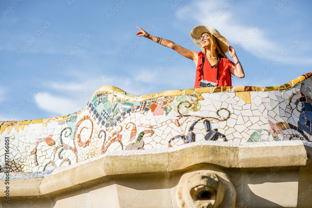 Obraz premium View on the beautiful terrace decorated with mosaic with happy woman tourist in Guell park in Barcelona