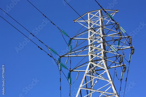 Top section of a Transmission Tower (Electricity Pylon) with vibrant Blue sky.