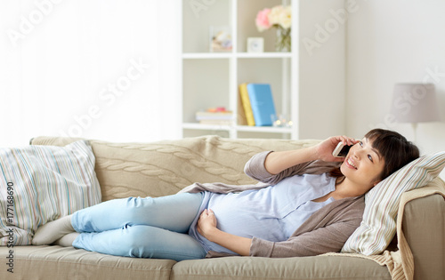 happy pregnant woman calling on smartphone at home