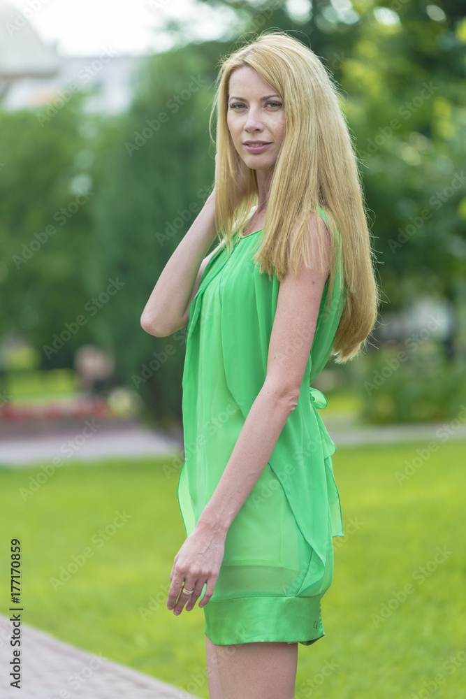 Beautiful blonde girl in a green short summer dress on the streets of the city
Beautiful blonde girl in a green short summer dress on the streets of the city