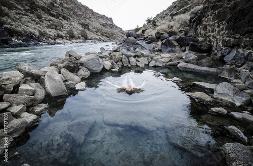 Woman Floating in Hotspring Near River. Rio Grande del Norte National Monument. New Mexico.  photo