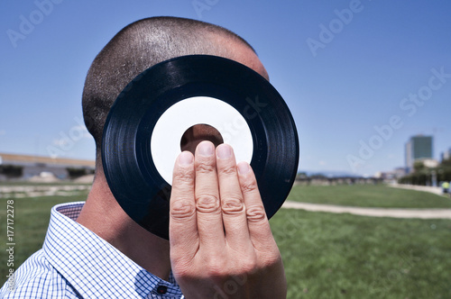 young man with a 45 rpm record at the park photo