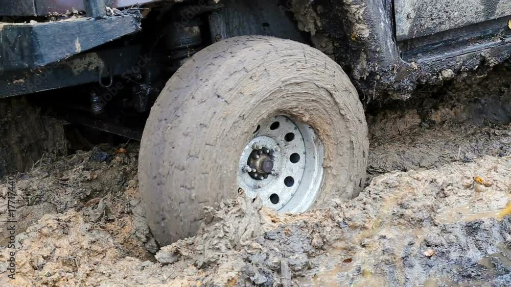 SUV 4WD car stuck in muddy off-road. Closeup the wheel rotates in the mud. SUV 4WD car stuck in muddy off-road. Closeup the wheel rotates in the mud.