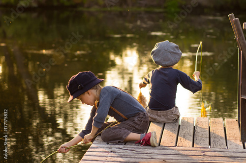 Laughing children sitting with sticks in hands