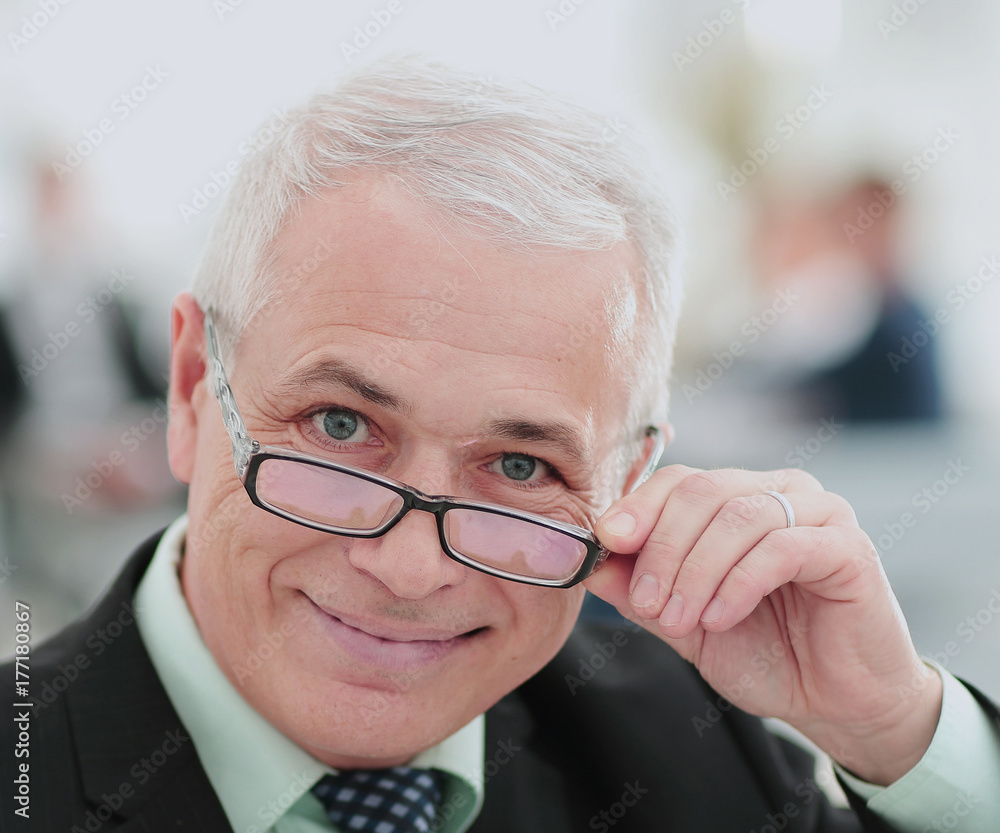 Portrait of mature businessman with  colleagues interacting on b