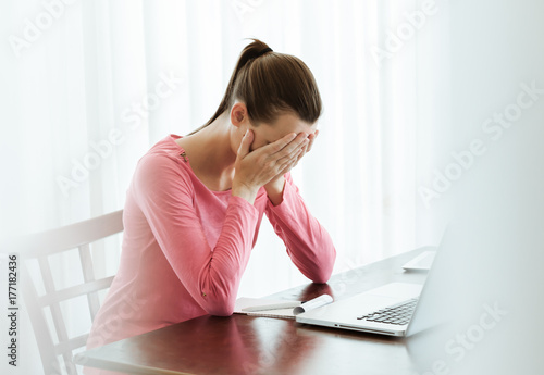 Stressed woman at work sitting in front of computer. 