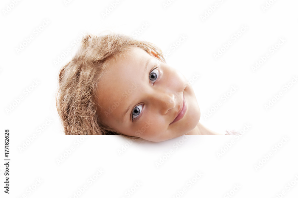 Smiling 7 years old girl look outs from the empty banner with space for text, isolated on white. Smiling 7 years old girl look outs from the empty banner with space for text, isolated on white.