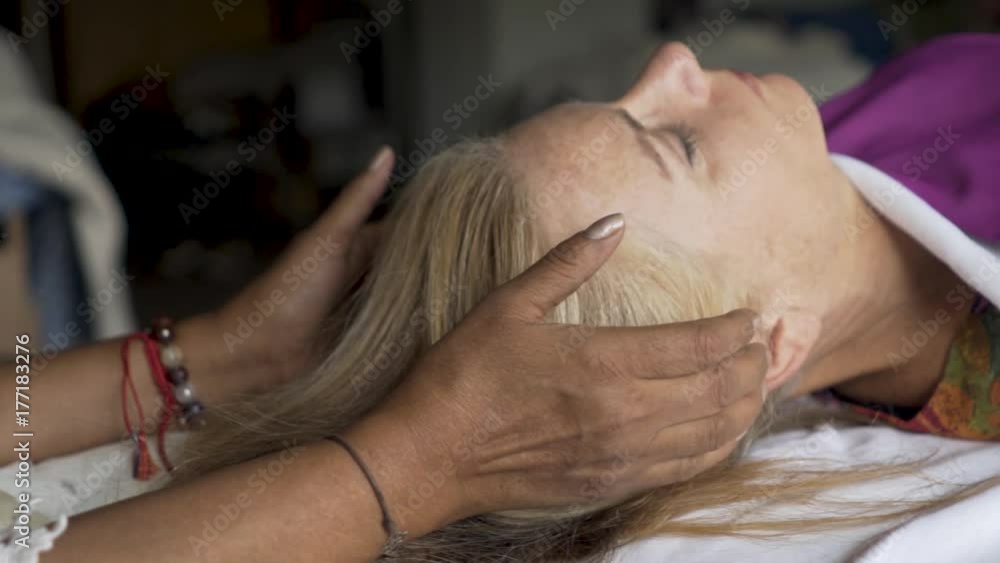 Very tight shot of a polarity therapist with her hands near her patient’s head feeling her energy. Very tight shot of a polarity therapist with her hands near her patient’s head feeling her energy.