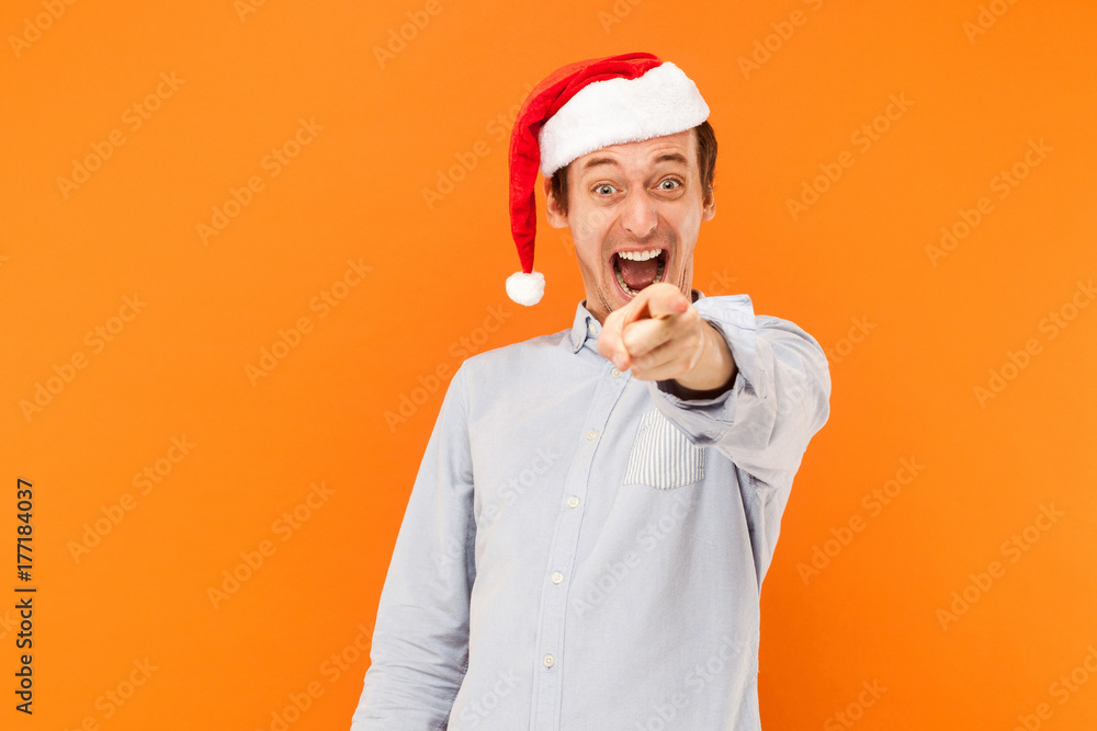 Hey you! It's new year! Attractive man pointing finger at camera, and toothy smiling. Focus on face. Hey you! It's new year! Attractive man pointing finger at camera, and toothy smiling. Focus on face.