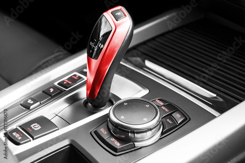 Red Automatic gear stick of a modern car, car interior details. Black and white