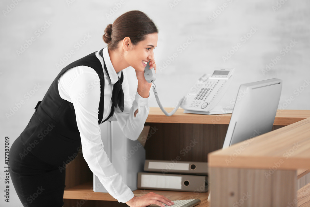 Female receptionist talking on phone in hotel Female receptionist talking on phone in hotel