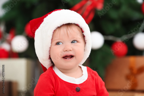 Cute baby in Santa hat agai...