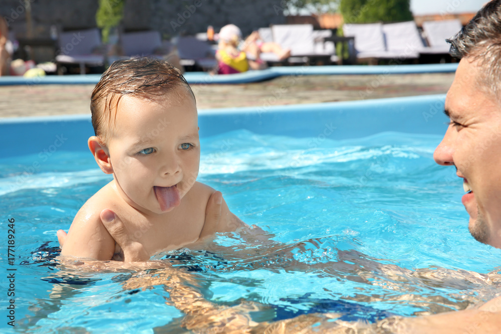 Child swimming lesson. Cute little boy learning to swim with father in pool