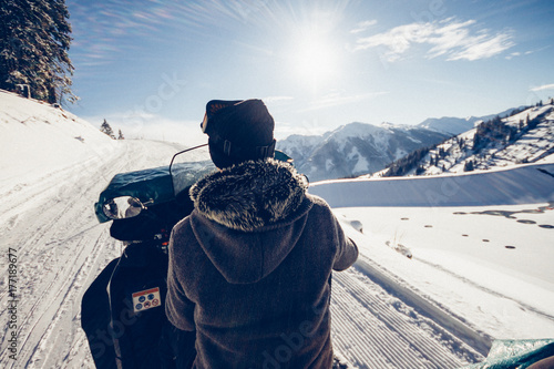 man driving snowmobile in snowcoverd landscape photo