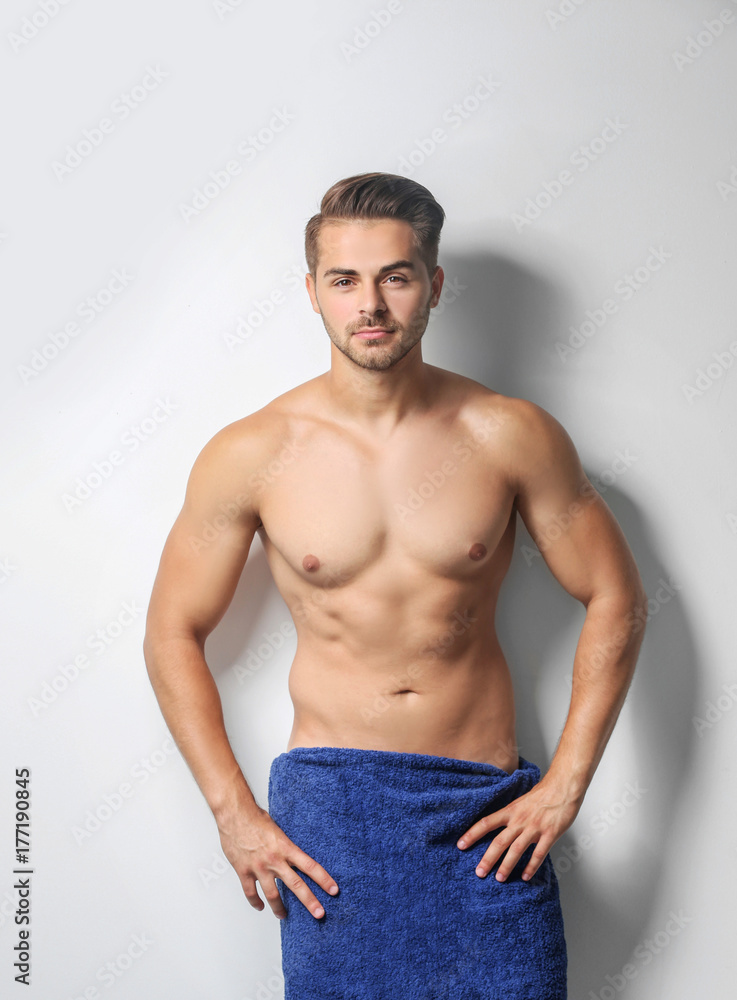 Fototapeta premium Sexy man wrapped in towel on white background