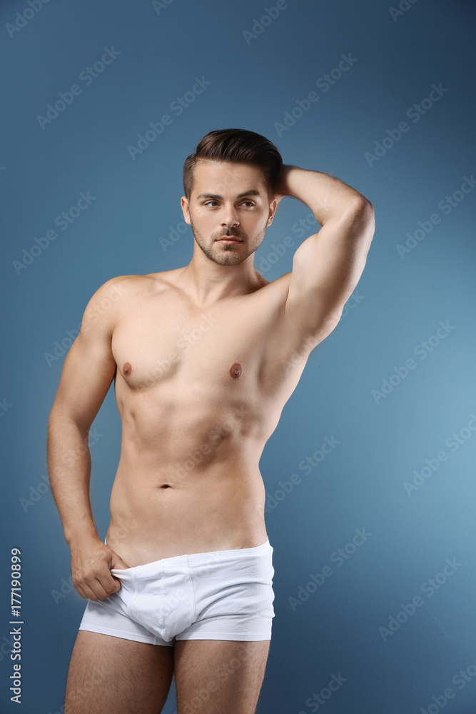 Sexy shirtless man in underwear on color background