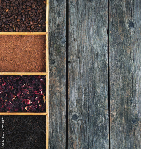 Grains of coffee, cocoa powder, karkade and black tea in box, panorama.