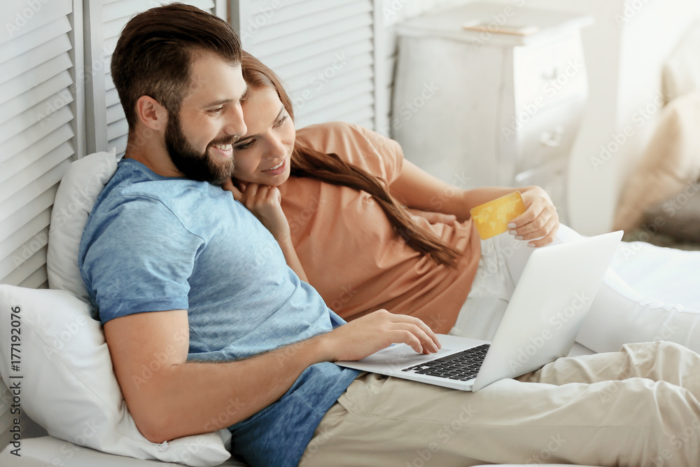 Obraz premium Young couple with laptop at home. Internet shopping concept