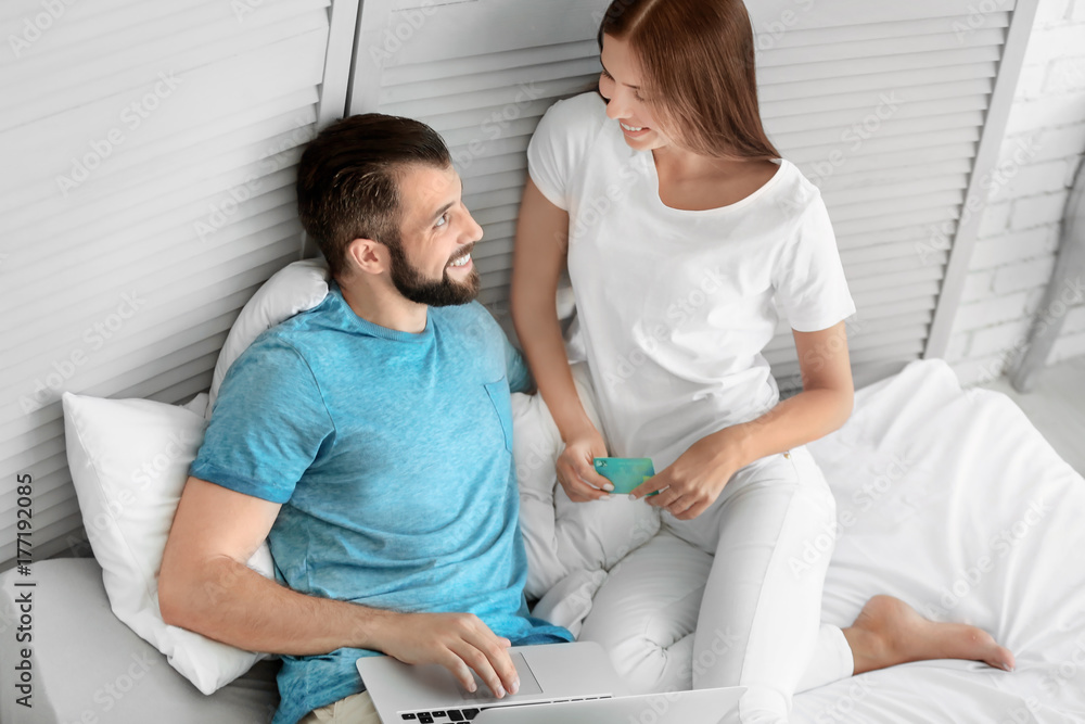 Obraz premium Young couple with laptop at home. Internet shopping concept