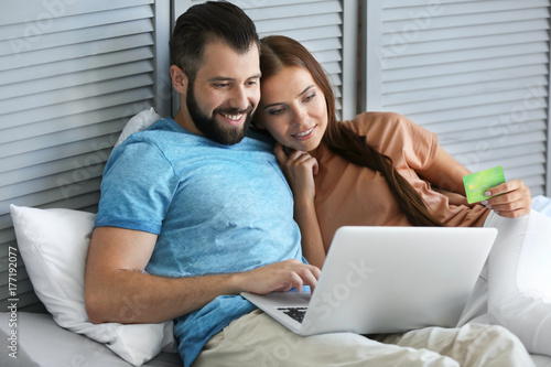 Young couple with laptop at home. Internet shopping concept © Africa Studio