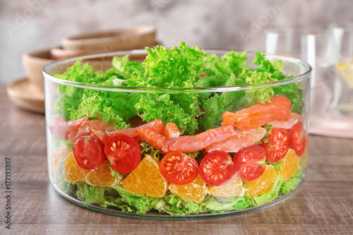 Bowl with delicious salmon salad on table