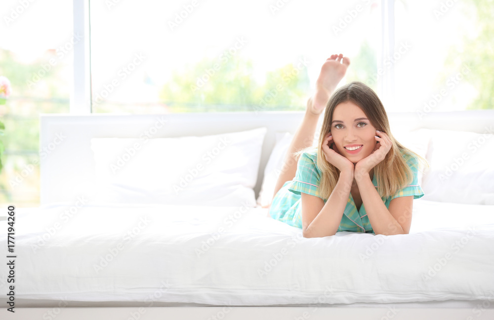 Young woman lying on bed in morning
