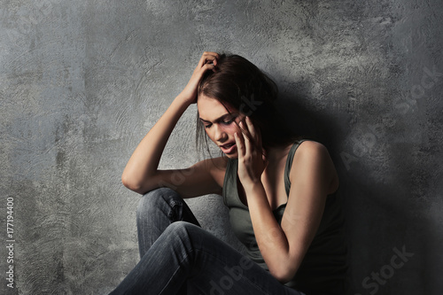 Battered young woman sittin...