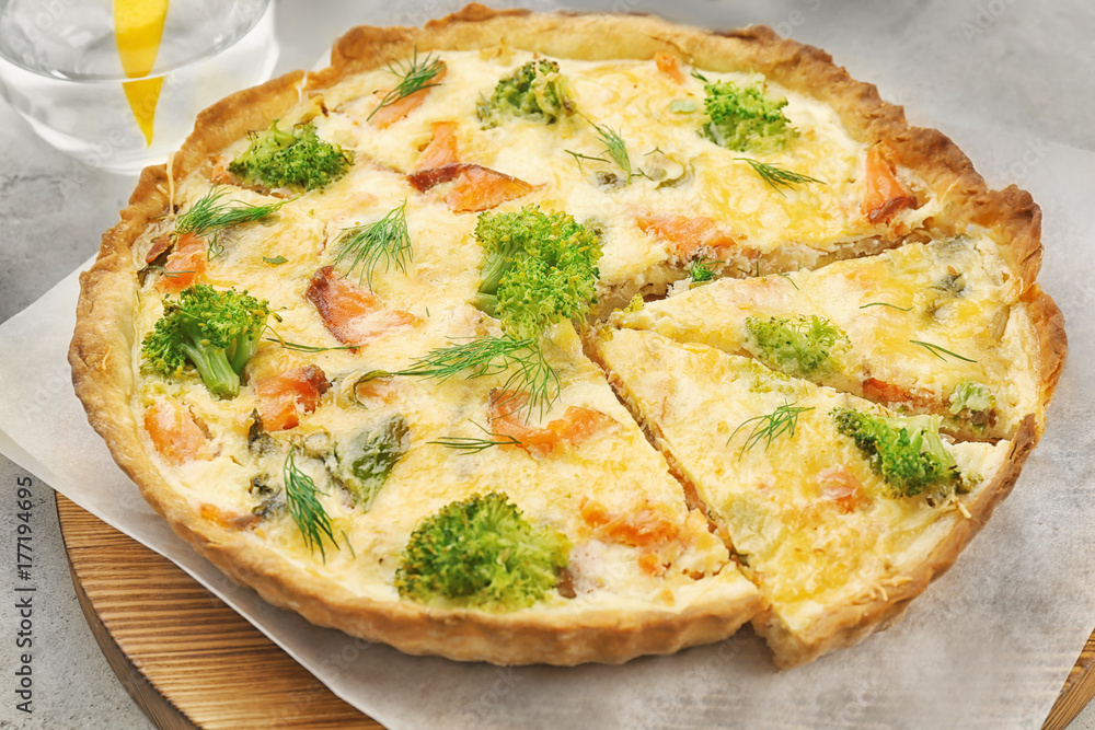 Tasty salmon quiche on wooden board Tasty salmon quiche on wooden board