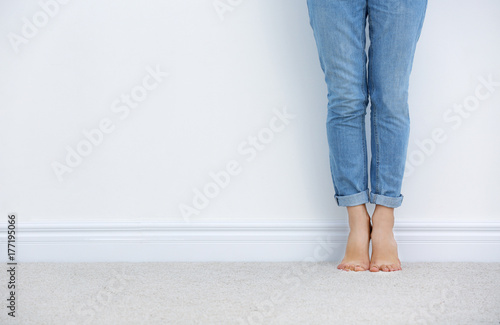 Woman standing on carpet near white wall