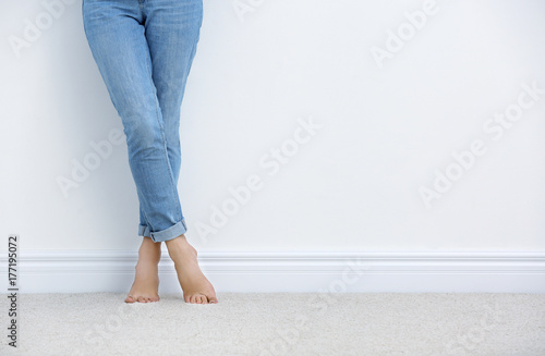 Woman standing on carpet near white wall