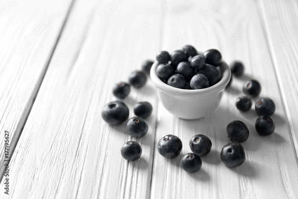 Bowl with fresh acai berries on wooden table Bowl with fresh acai berries on wooden table
