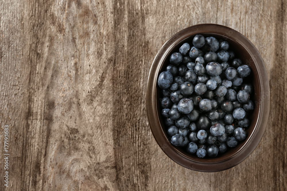 Bowl with fresh acai berries on wooden table Bowl with fresh acai berries on wooden table