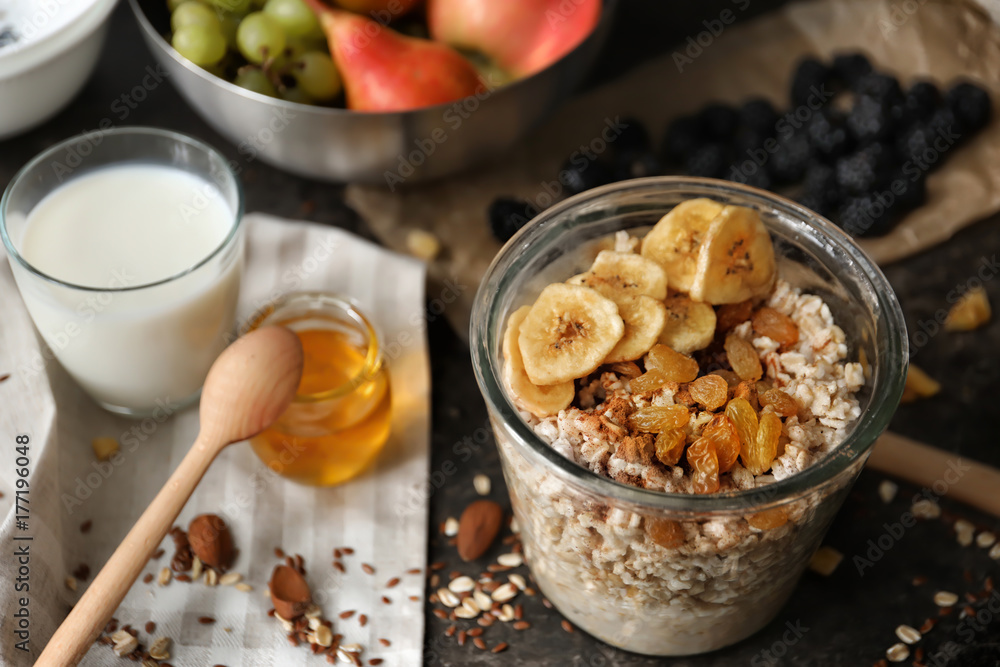 Nutritious oatmeal with banana and raisins in glass on table Nutritious oatmeal with banana and raisins in glass on table