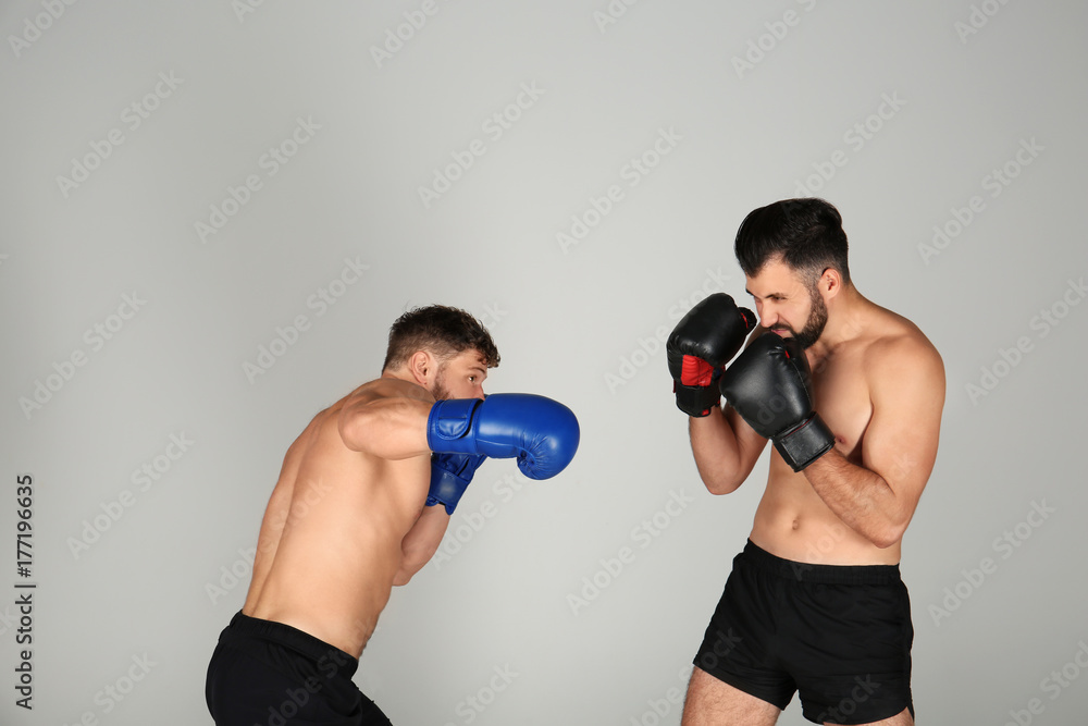 Male boxers fighting on light background Male boxers fighting on light background