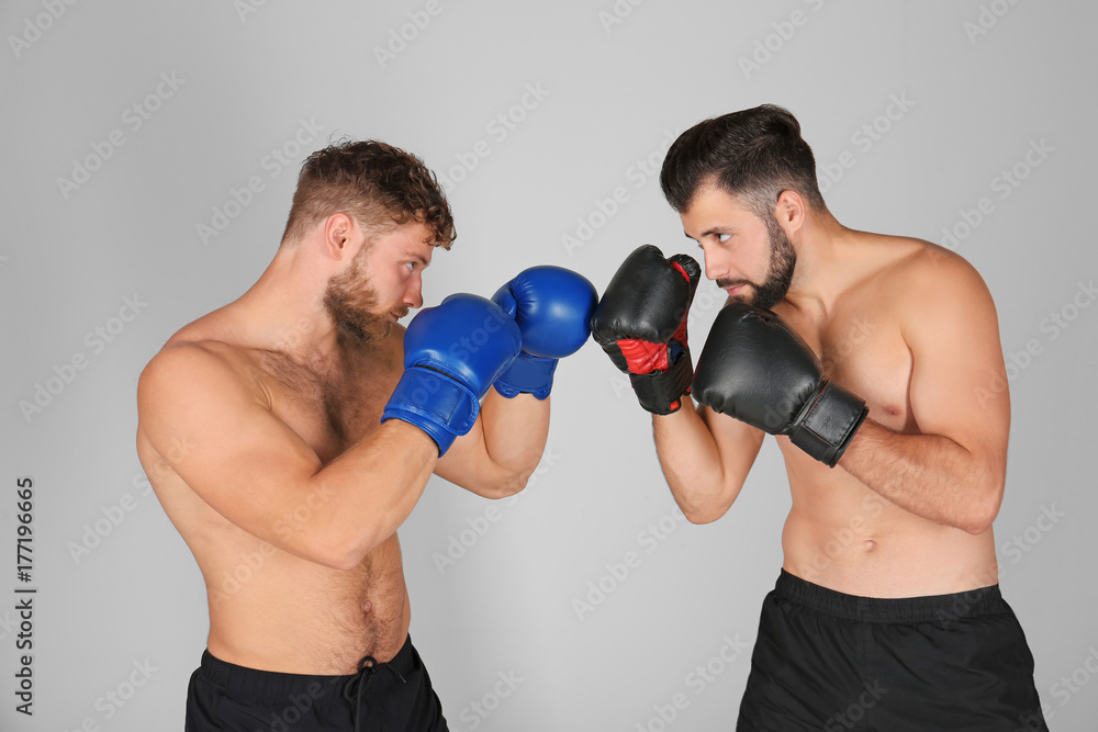 Male boxers fighting on light background Male boxers fighting on light background