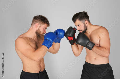 Male boxers fighting on light background © Africa Studio