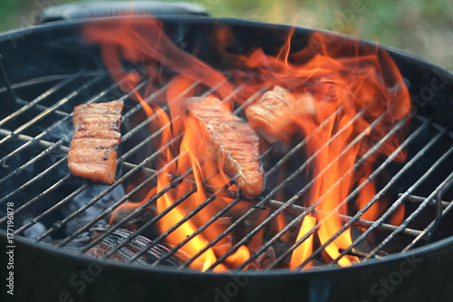 Tasty salmon slices on barbecue grill outdoors