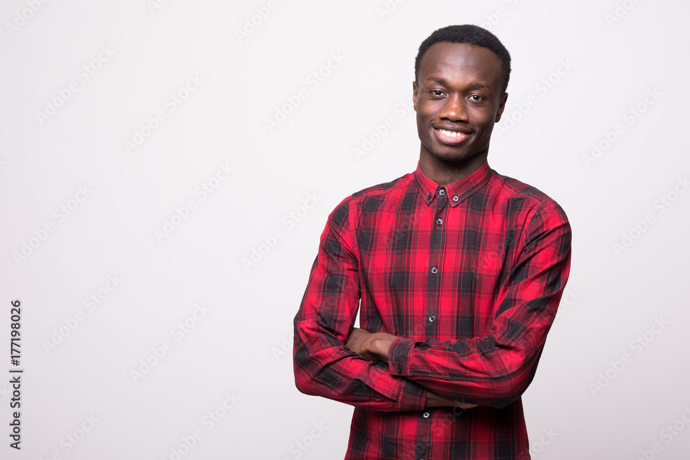Smiling african guy with crossed arms against white background Smiling african guy with crossed arms against white background